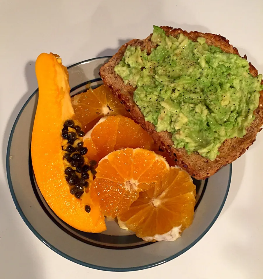 Mashed Avocado on multigrain toast with orange rings and papaya|victoria valerioさん