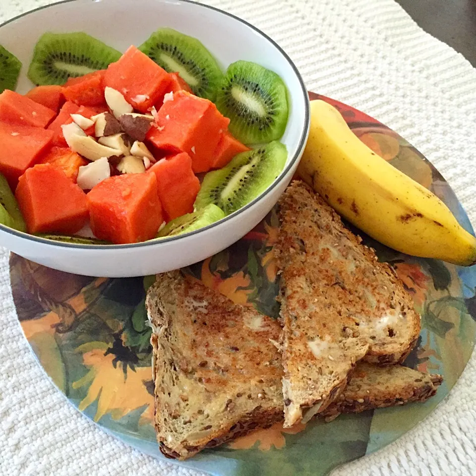 Fruit bowl: papaya, kiwi and Brazil nut with a mini banana and dave's good seed toast with earth balance butter|victoria valerioさん