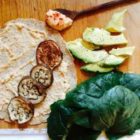 Vegan wrap: whole wheat tortilla with homemade hummus, spinach, roasted eggplant, peppered avocado and cucumber