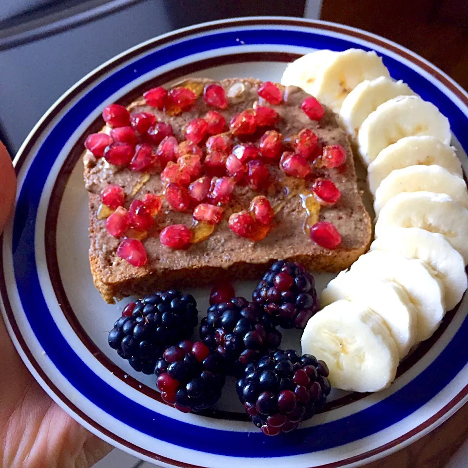 Whole wheat toast with almond butter, pomegranate, honey and cinnamon paired with banana and blackberries|victoria valerioさん