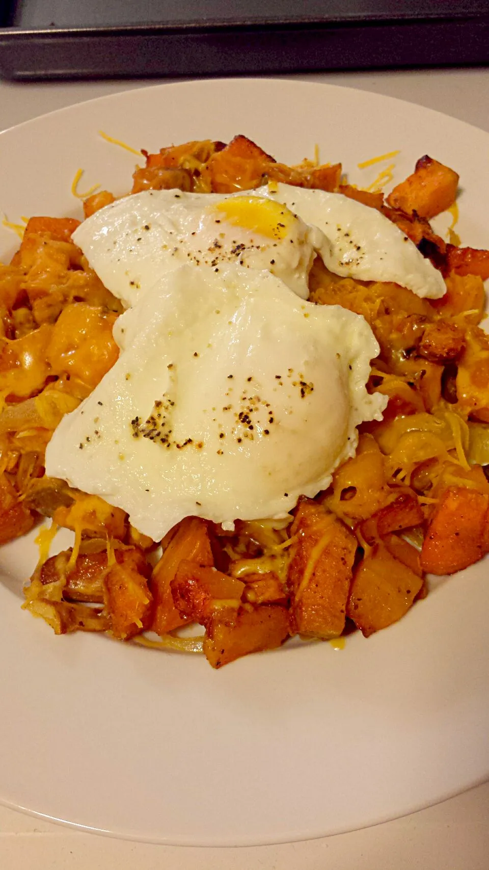 roasted butternut squash and sweet potato hash topped with cheddar cheese and poached eggs|Brianaさん