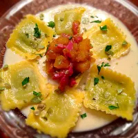 Arugula Parmesan ravioli in a parm cream sauce topped with pan seared prosciutto and roasted butternut squash In a Demi glacé. Garnish with edamame beans and pa|Troy Craneさん