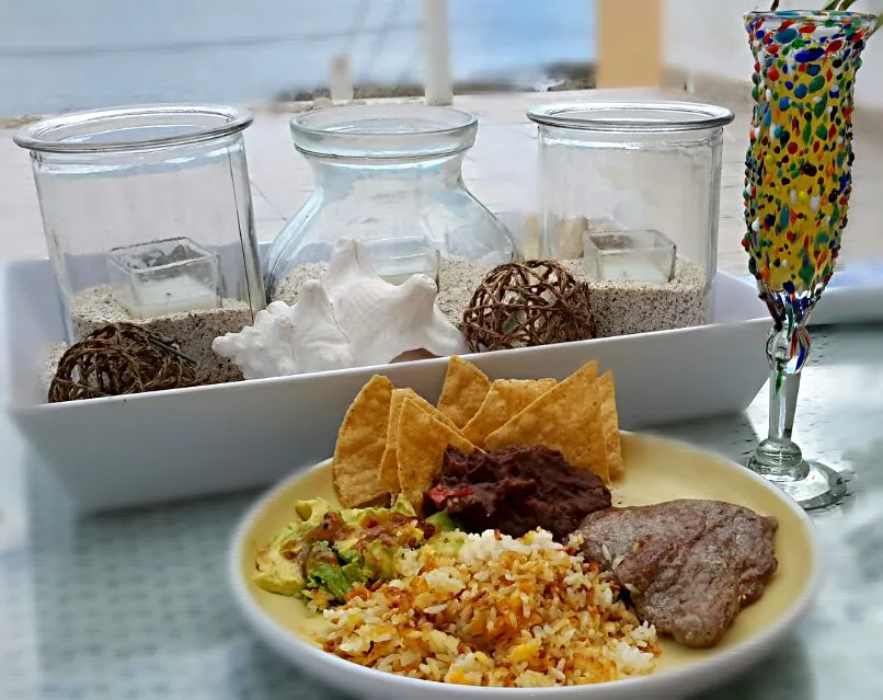 Steak with fried rice, avocado, black beans & chips accompanied by a glass of mimosa|Jiraphon Gさん