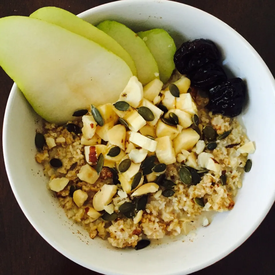 Steel cut oats with almond milk, pumpkin spice, diced banana, prunes, pears, pumpkin seeds and crushed Brazil nuts with a drizzle of honey|victoria valerioさん