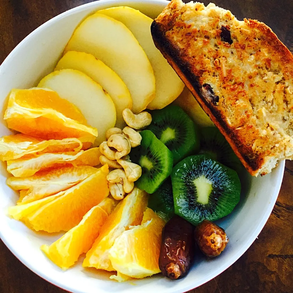 Fruit bowl (Orange, kiwi, dates, pear), cashews and a slice of toasted homemade bread with earth balance butter|victoria valerioさん