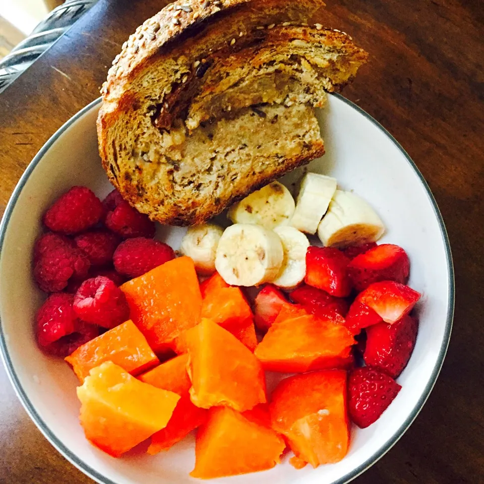 Breakfast fruit bowl with a slice of artesian multi grain bread|victoria valerioさん