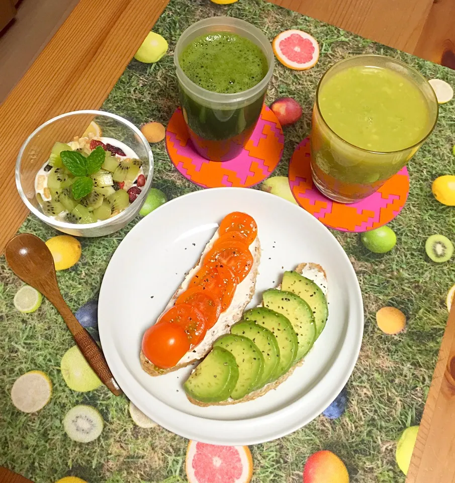 Vegetarian breakfast with avocado ginger and grapefruit juice, avocado tomato cream cheese on homemade rye bread, kiwi and granola on yogurt, and a glass of spi|Kumigarさん