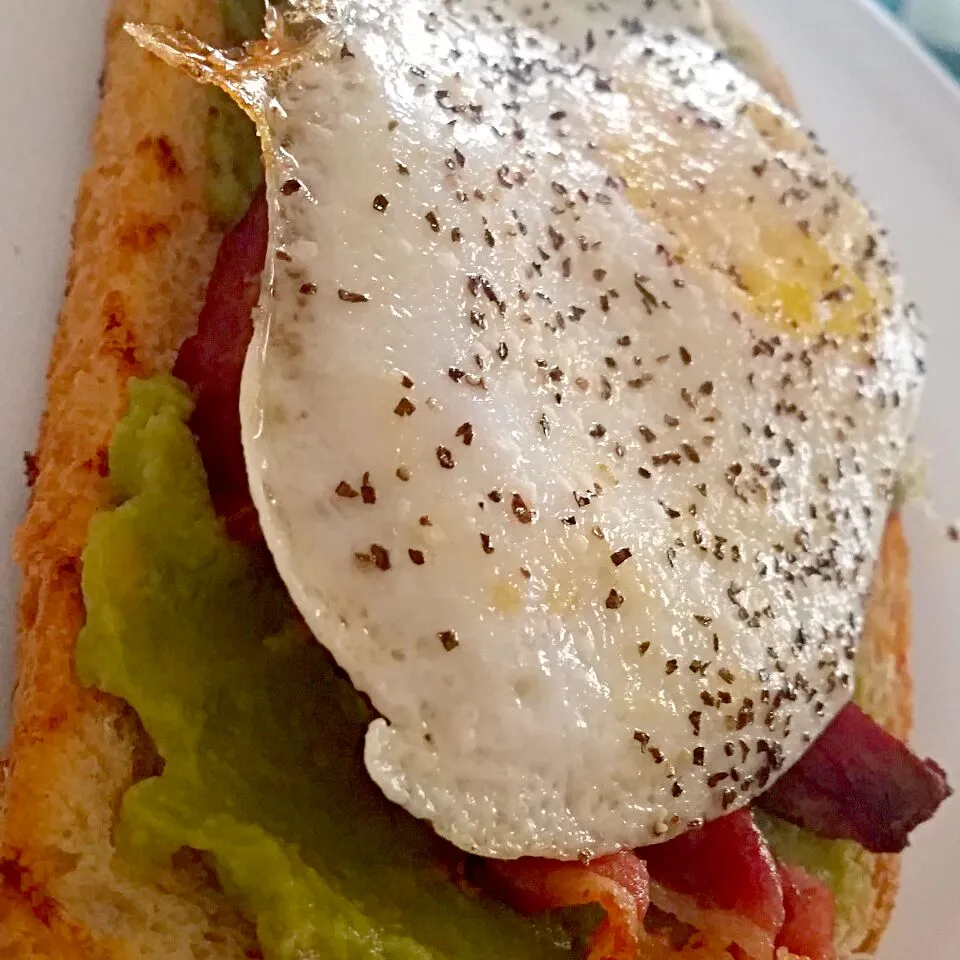 Snapdishの料理写真:Three Cheese Toast topped with Guacamole, Bacon and Over Easy Eggs|Crystal Carltonさん