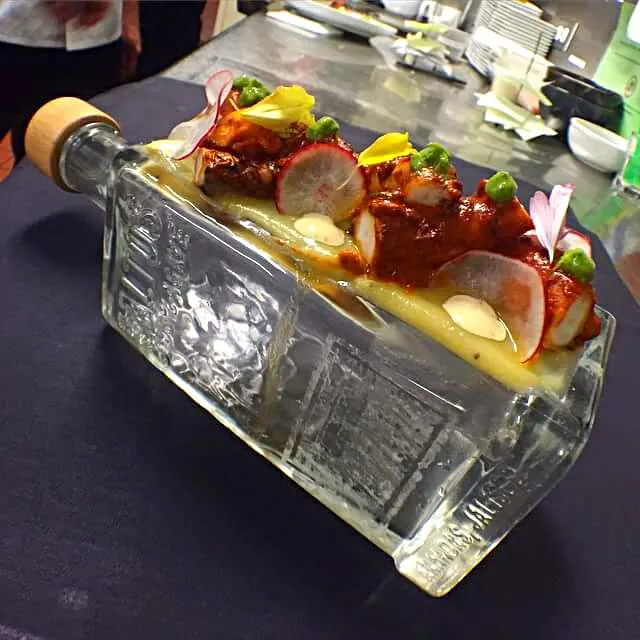 octopus in chorizo sauce on top of a tequila bottle|CHUENCHAIさん