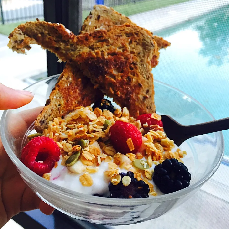 Chobani peach yogurt bowl with banana, rasberries, blackberries and granola. Side of seed bread with earth balance spread|victoria valerioさん