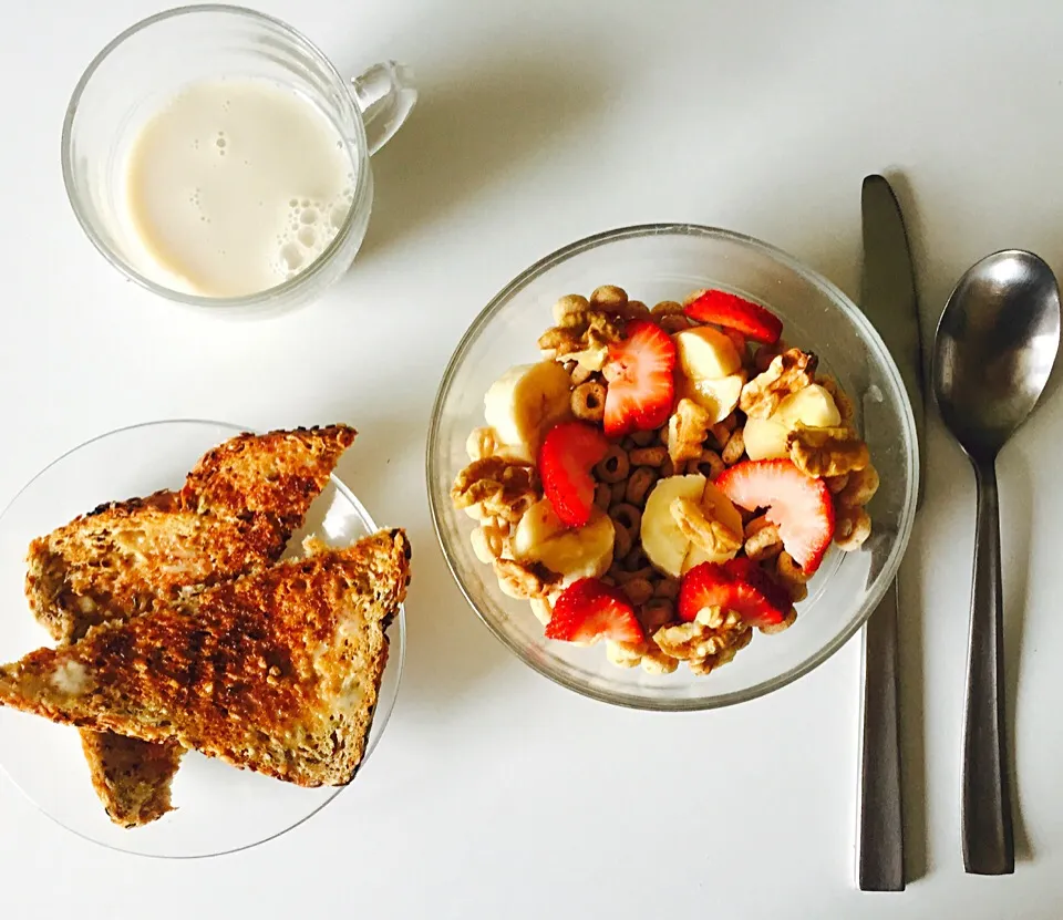 Whole wheat toast with earth balance butter and a bowl of Cheerios with walnuts, banana, strawberry, cinnamon and almond milk.|victoria valerioさん