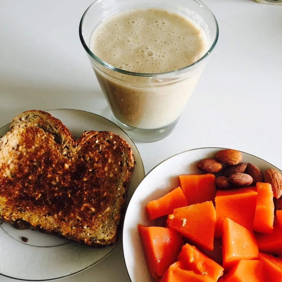 Banana, almond milk, cinnamon oat smoothie with whole wheat toast with earth balance butter spread and a side of papaya with almonds|victoria valerioさん