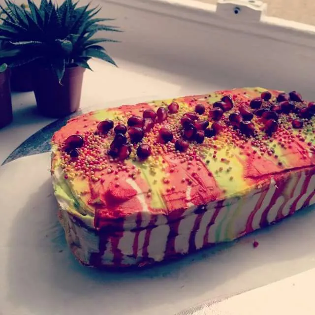 Rainbow sponge cake inside polka dots, topped with candied pomegranate seeds and sprinkles|CHUENCHAIさん