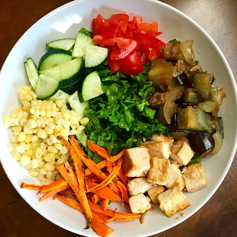 Green garden bowl: eggplant tofu with baked carrots, corn, cucumbers and tomatoes over a bed of romaine lettuce|victoria valerioさん