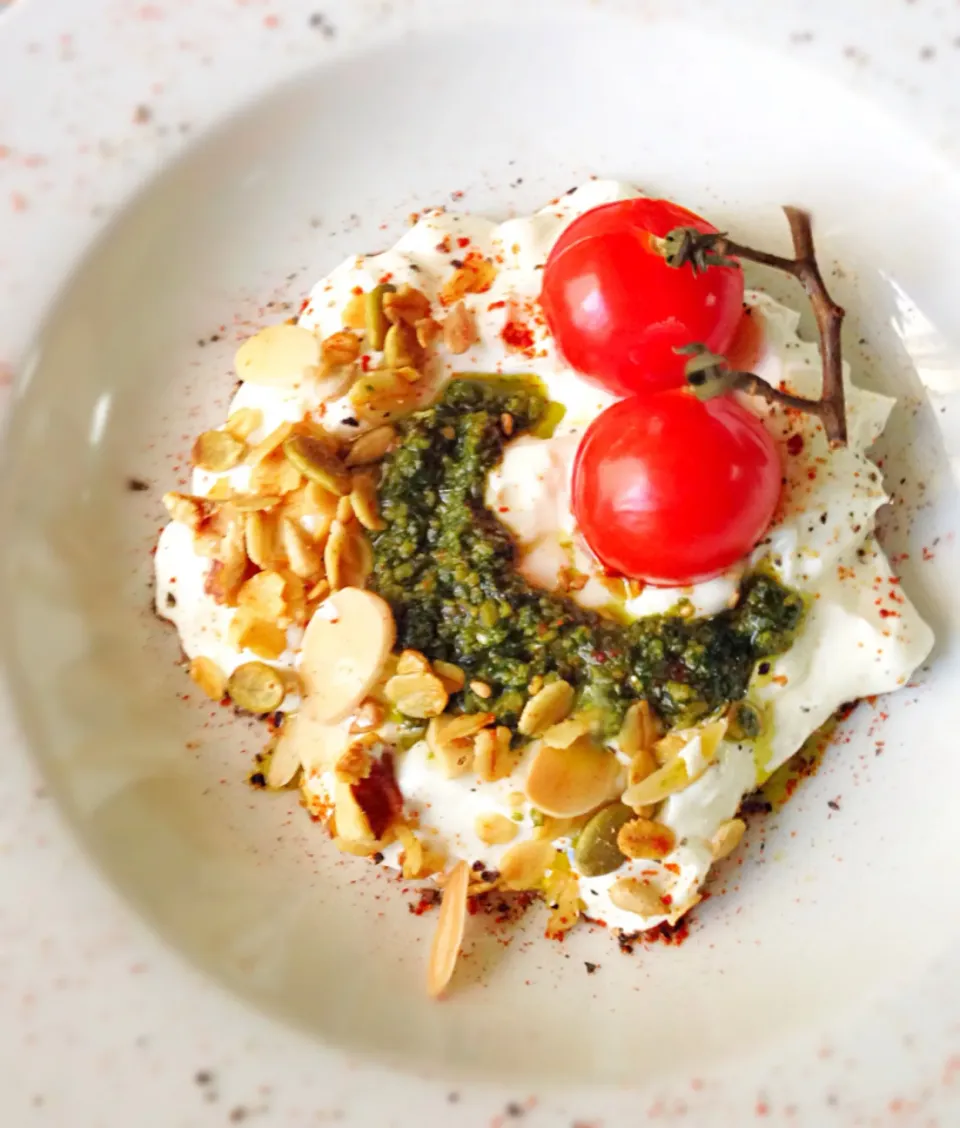 Savory yogurt breakfast - Greek yogurt with curry coconut granola, homemade basil almond pesto and roasted tomatoes, sprinkled with paprika and black pepper|coxiella24さん