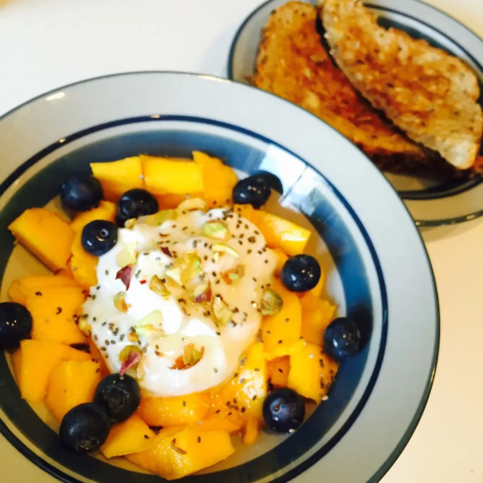 Snapdishの料理写真:Mango and blueberries with Greek yogurt, pistachios, chia seeds and agave. Side of toast with earth balance butter|victoria valerioさん