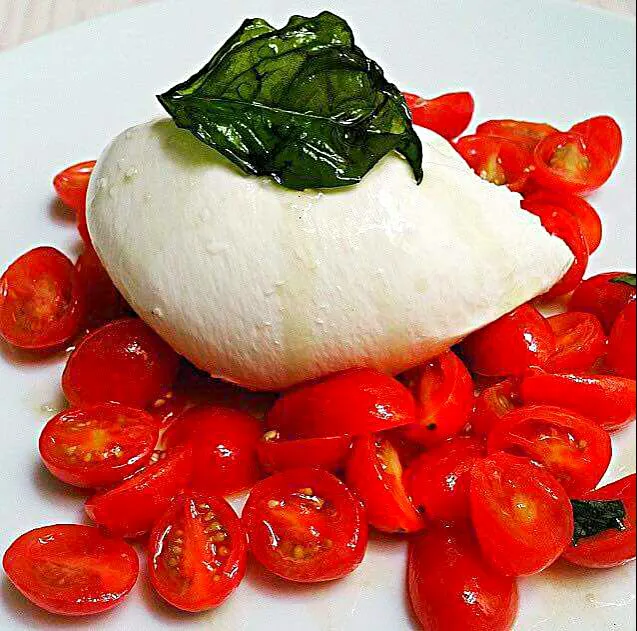 Cherry tomatoes topped with buffalo mozzarella drizzled with olive oil|CHUENCHAIさん