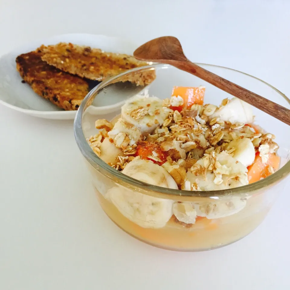 Applesauce bowl topped with mini banana coins, papaya, walnuts and homemade granola with a side of toast|victoria valerioさん