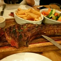 Tomahawk stake served with mushroom sauce, veggies and chips|Thai Hien Nguyenさん