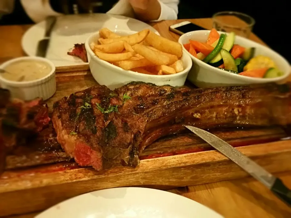 Tomahawk stake served with mushroom sauce, veggies and chips|Thai Hien Nguyenさん