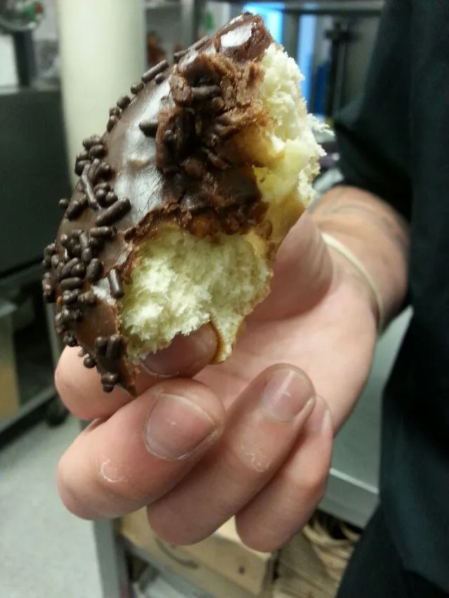 half eaten chocolate covered donut.|Polly Gelfusoさん