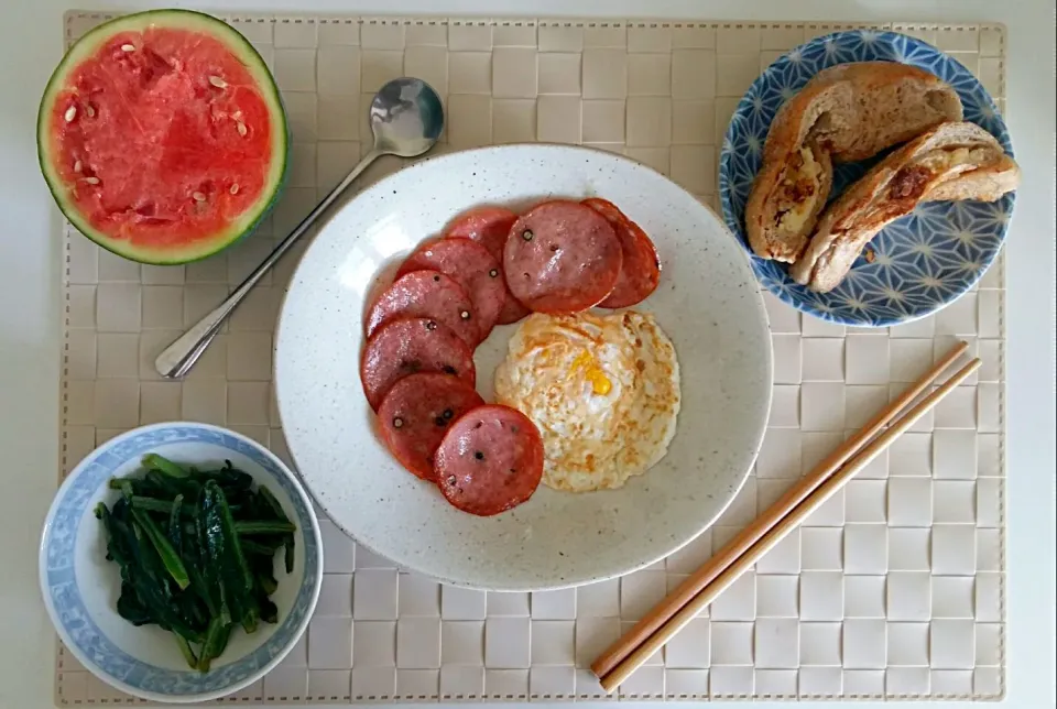 Breakfast: fried egg, salami, bread with cheese, fried lactuca sativa, mini watermelon|Liciaさん