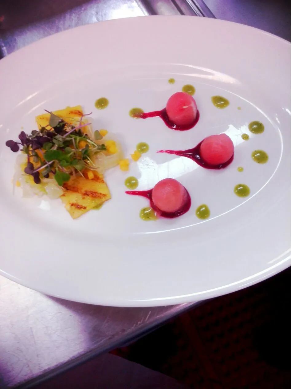 pickled fennel atop grilled pineapple napped with a mango salsa..accompanied by watermelon balls, raspberry coulis and thyme  vinaigrette|Garcia Jasnique Hallさん