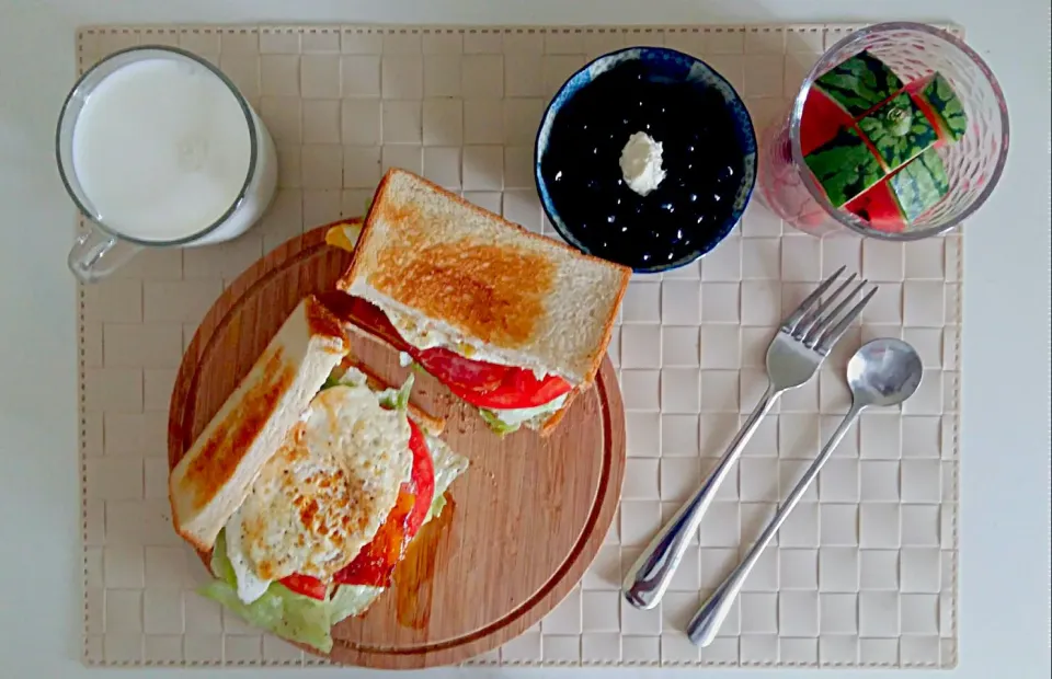 Snapdishの料理写真:Breakfast: panini (toast, lattuce, tomato, bacon, fried egg, cream cheese), blueberry with honey, mini watermelon stick,  milk.|Liciaさん