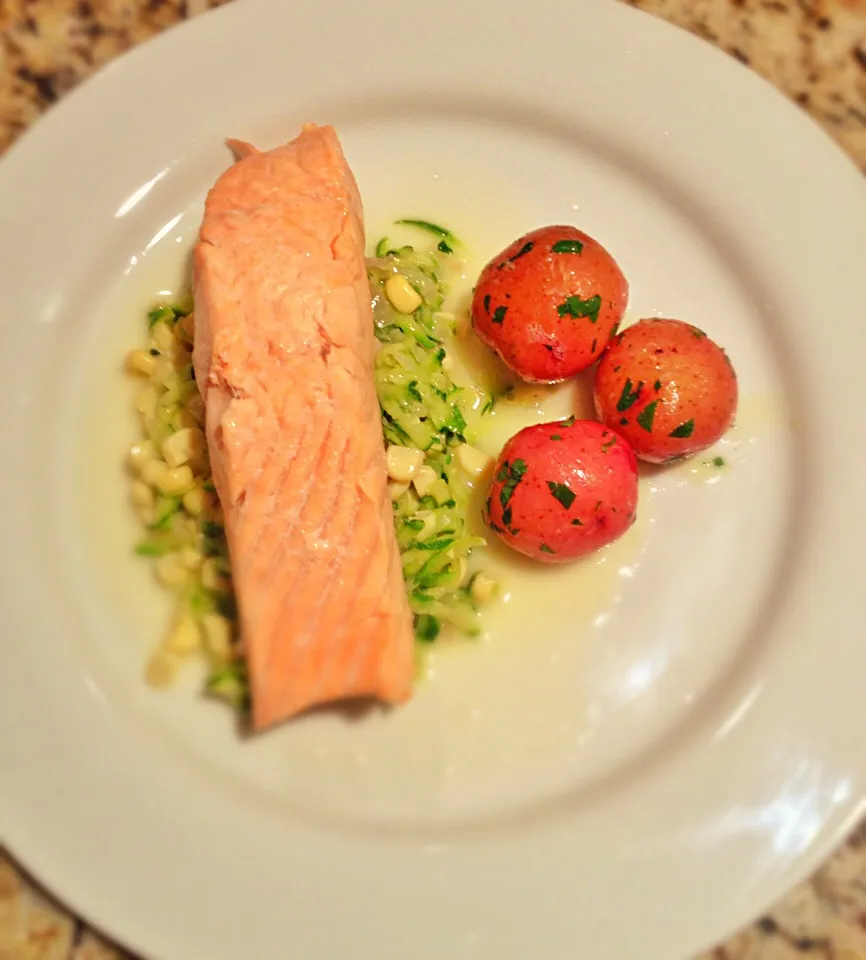 Poached salmon on sautéed fresh corn and shredded zucchini with a white wine butter sauce and a side of parsley new potatoes.|Allisonさん