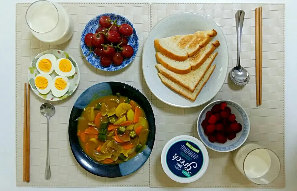 Breakfast for two: toast, fried vegetables with curry sauce, cream cheese, boiled eggs, grape and raspberry, soymilk mixed with milk.|Liciaさん