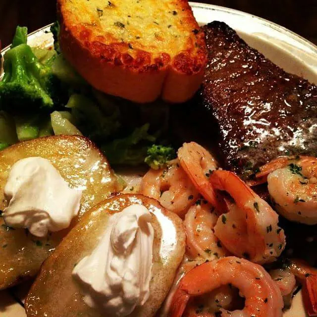 New York strip with garlic butter, shrimp scampi, broccoli, half baked potatoes with kosher salt and olive oil topped with sour cream and garlic butter and a si|CHUENCHAIさん