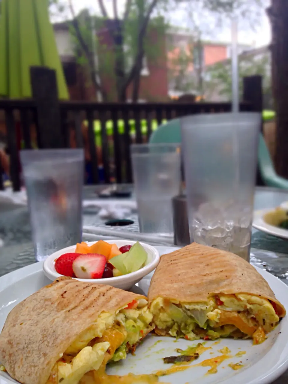 Breakfast burrito with a fruit cup and the remnants of an iced coffee|eliseさん