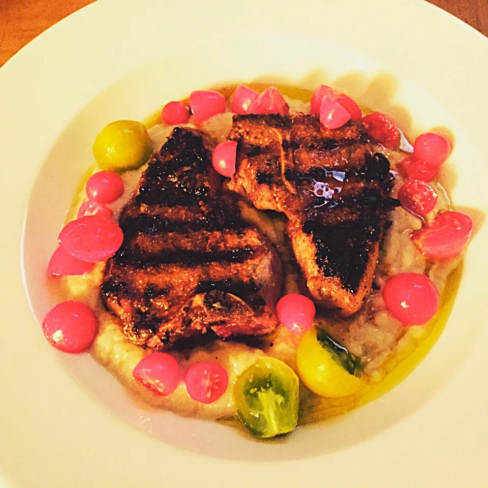 Grilled cumin lamb loin chops over creamy corn grits with heirloom cherry tomatoes. Truffle oil drizzle.|West Coast Southernerさん