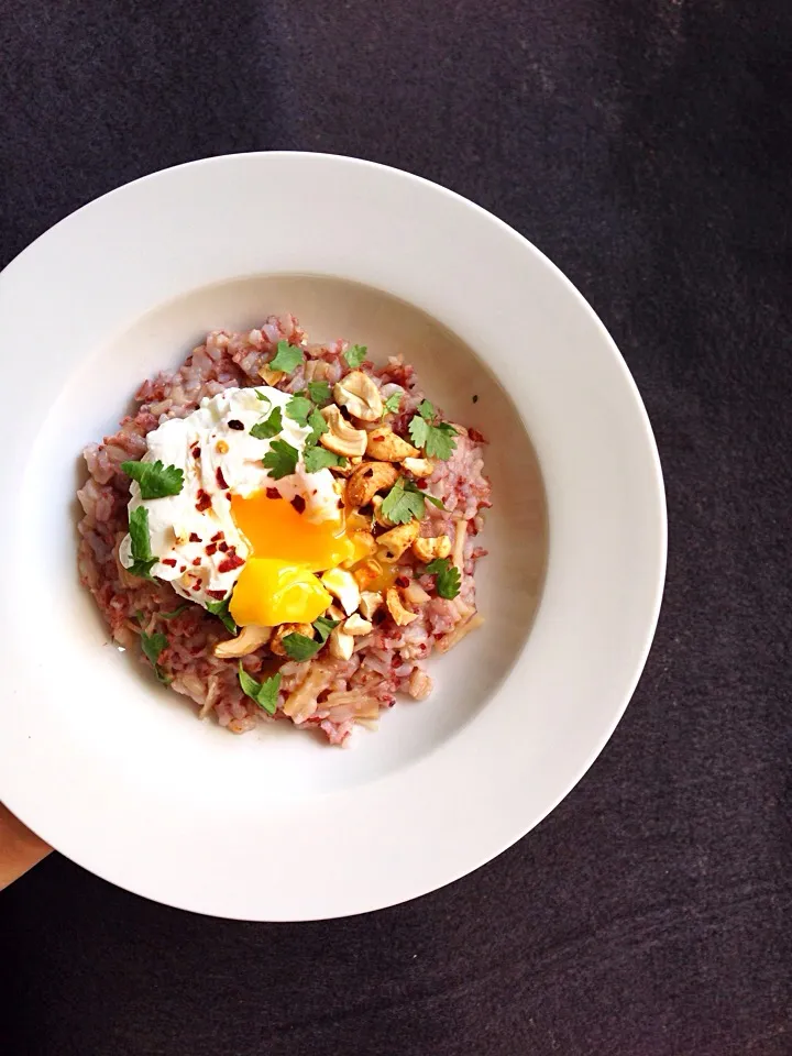 Red rice congee with spiced cashews, poached egg, coriander and chili flakes|coxiella24さん