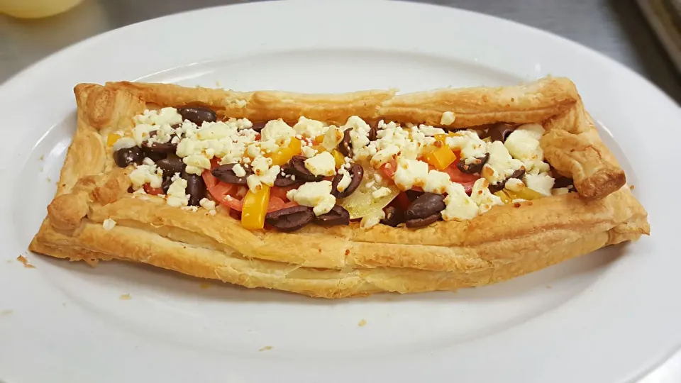 puff pastry appetizer with 3 different tomato slices black pitted olives and blue cheese|Louis Rodriguezさん