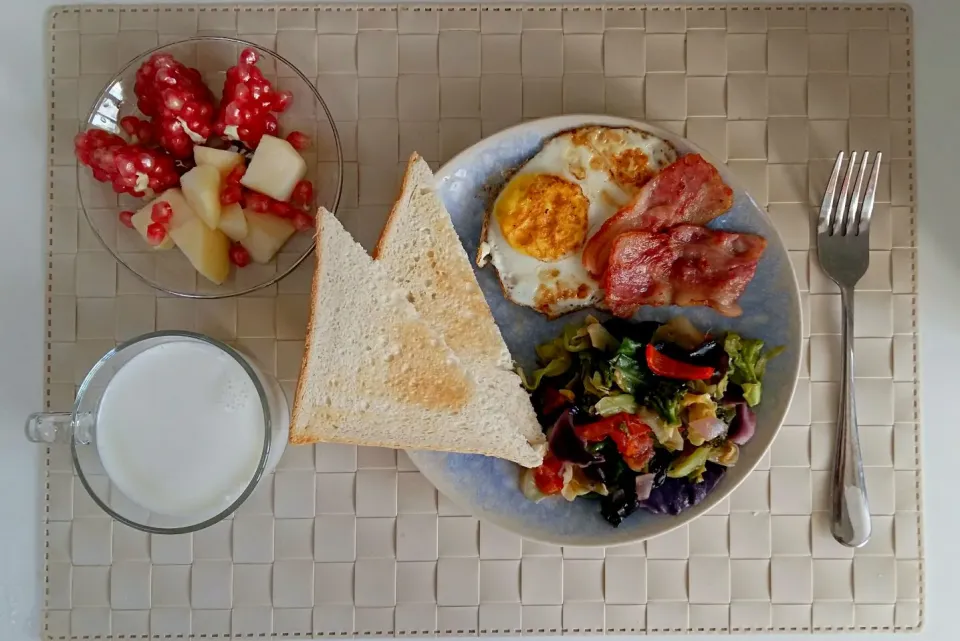 Breakfast: toast, fried egg, bacon, fried vegetable, apple & pomegranate.|Liciaさん