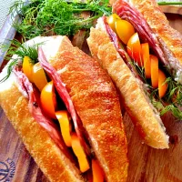 Sandwich with party leftovers: bruschetta baguette, Italian salami, tarako spread, dill and yellow grape tomatoes.|Kirk Awiamさん