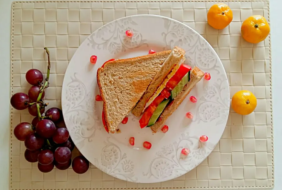 Breakfast: sandwich(fried egg, tomato and cumcuber, with raspberry jam, and sweet and spicy sauce), pomegranate, grape and mini orange.|Liciaさん