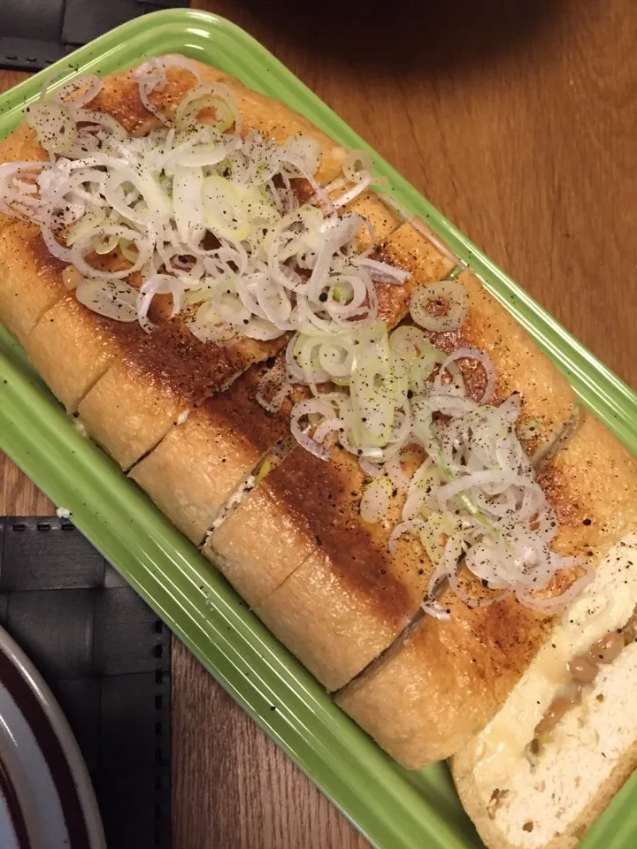 栃尾揚げにネギだく納豆にとろけるチーズをこれまたたっぷり入れたものを挟んで焼きました。ネギと黒七味とポン酢でさっぱりと。|MORiさん