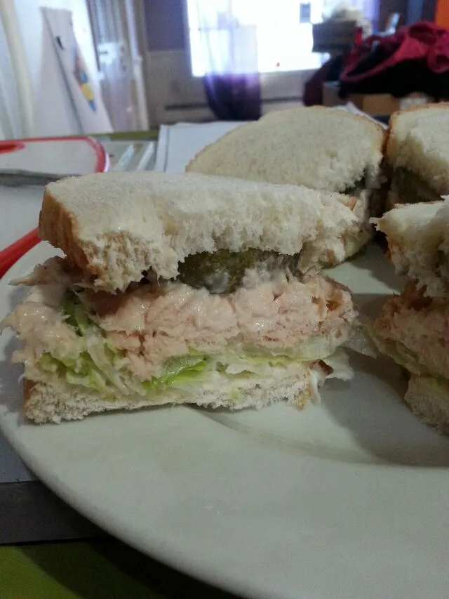 tuna salad sandwiches with lettuce and pickles.|Polly Gelfusoさん