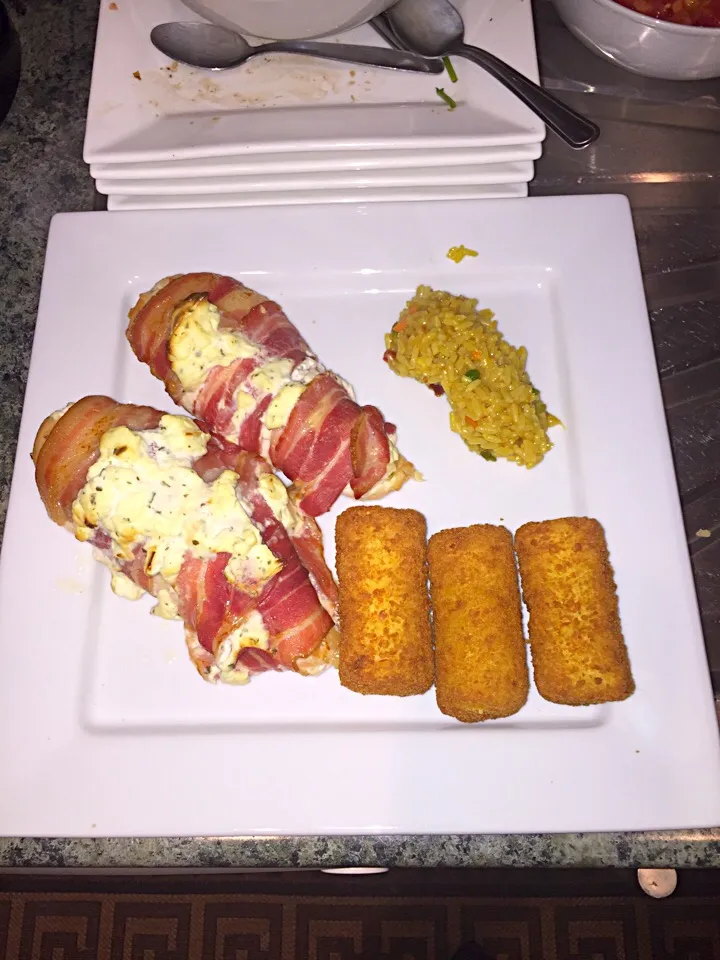 Chicken with garlic sauce wrapped in bacon. Served with veg rice and potato croquettes.|Daniel Allchinさん