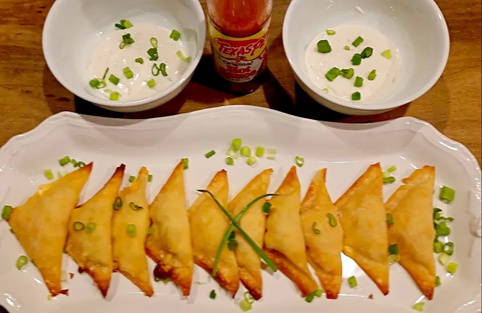 Low calorie baked wontons buffalo chicken, made with chopped cooked chicken, hot sauce, fat free cream cheese, and fat free cheddar cheese. With ranch dressing |Cooking My Butt Offさん