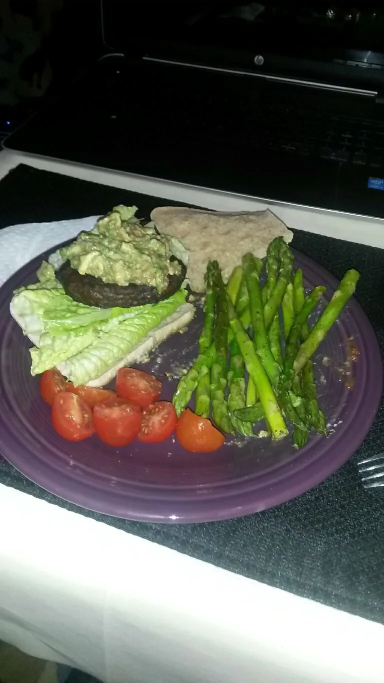 Beef pattie with Romaine lettuce, topped with homemade guacamole, a whole wheat sandwich thins,  cherry tomatoes and asparagus cooked with a tsp of coconut oil,|Jennifer Powellさん