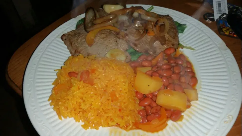 pan seared steak was on the yellow rice pink beans on a bed of baby spinach and onions|Frank Ortizさん