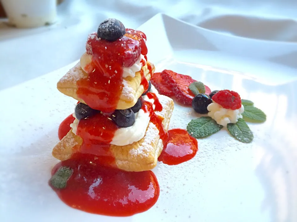 Mixed berries dessert with strawberry coulis and whipped cream|laura giardinaさん