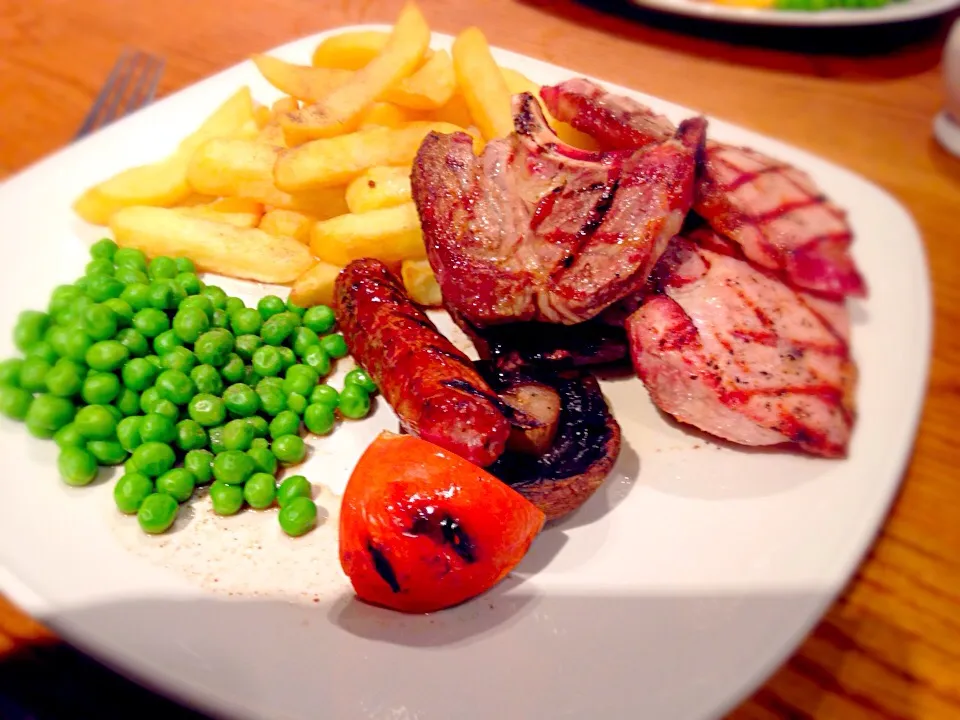 Mixed grill.  Gammon, pork chop, lamb chop, sausage , tomato, peas & chips.|Karla Collington Ryderさん