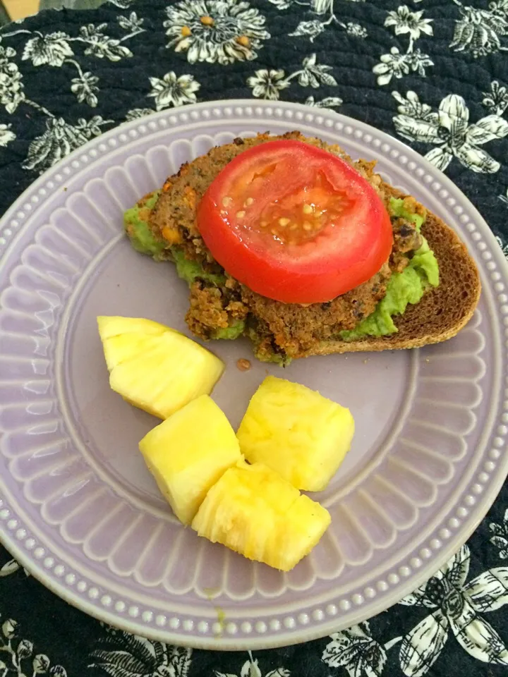 Open faced veggie burger with guacamole and tomato. Side of pineapple. (Half way eaten!)|sarah rose chaconさん