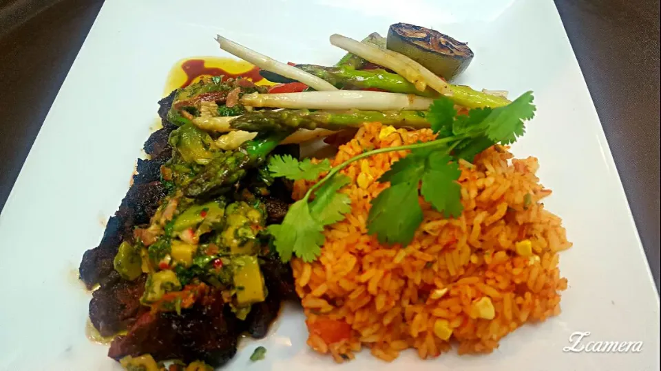 marinated hanger steak with a bacon avocado chimichurri sauce served with Spanish style rice and green and white asparagus|chef Charlesさん