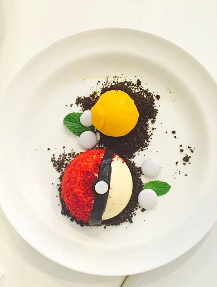 Pokéball🙃by Spot Dessert Bar, made of white chocolate mousse filled with mango passion fruit syrup and finished off with red velvet and Oreo crumbs.|MyRaXさん