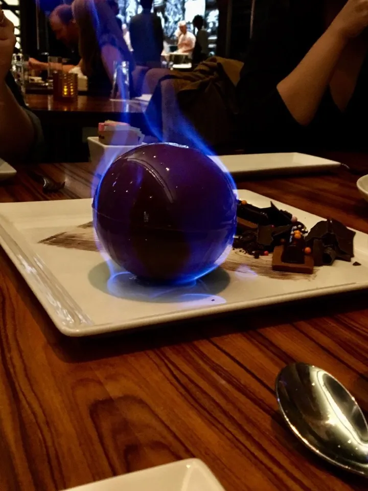 Chocolate sphere filled with marshmallow and caramel ganache. Doused in rum and lit on fire tableside. Morimoto Las Vegas|robert flickerさん